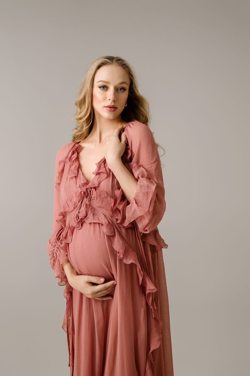 Artistic maternity session with soft silhouette and natural tones
