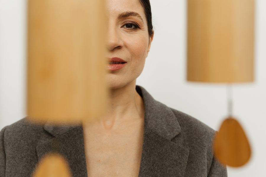 Refined portrait of a woman in natural linen against a minimalist backdrop